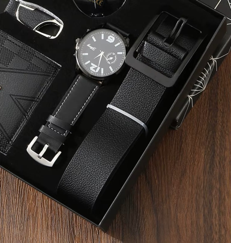 Black leather watch, strap, and wallet set in a box on a wooden surface